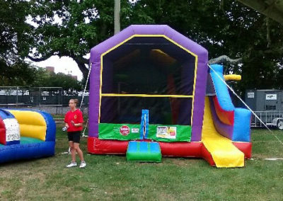 Inflatable 5-1 Combo featuring moonwalk, slide, basketball hoops, and twister game