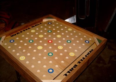 Table top game with legs. Toss a small waffle ball onto the table and try to get it into the colored circles.